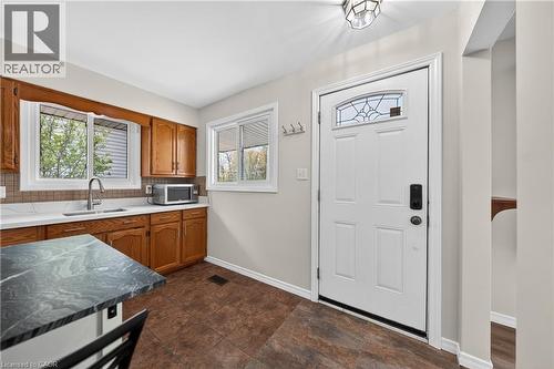 Kitchen area featuring wood cabinetry, white countertops, and a tiled backsplash - 34 Avenue Road, Cambridge, ON - Indoor Photo Showing Kitchen