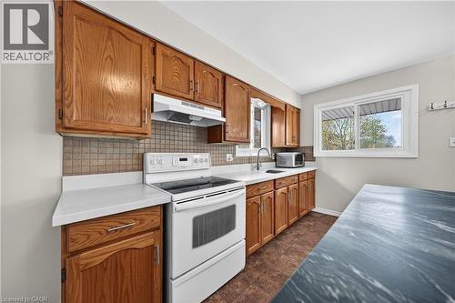 Kitchen featuring wood cabinetry, white countertops, a tiled backsplash, and a white range - 34 Avenue Road, Cambridge, ON - Indoor Photo Showing Kitchen