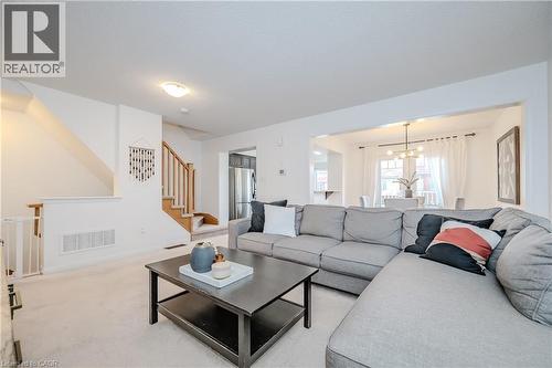 Bright living area featuring light-toned carpeting and white walls - 525 Cavanagh Lane, Milton, ON - Indoor Photo Showing Living Room