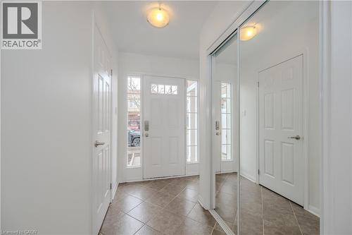 Entryway featuring a paneled front door with sidelights, transom windows, and a mirrored closet with sliding doors - 525 Cavanagh Lane, Milton, ON - Indoor Photo Showing Other Room