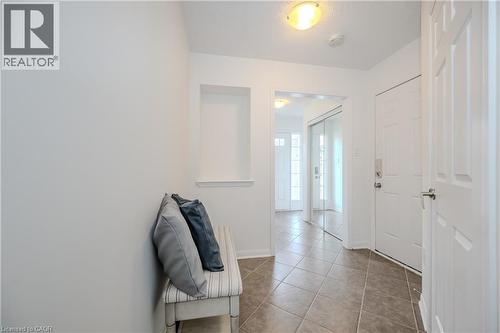 Foyer entry featuring ceramic tile flooring, a built-in wall niche, white panel doors, and a mirrored closet - 525 Cavanagh Lane, Milton, ON - Indoor Photo Showing Other Room