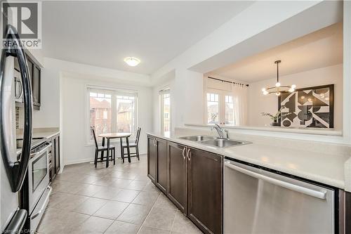 Bright kitchen with a pass-through opening to the dining area - 525 Cavanagh Lane, Milton, ON - Indoor Photo Showing Kitchen With Double Sink