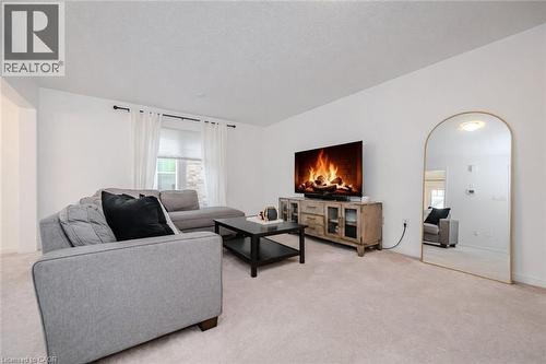 Bright living room featuring light-toned carpeting and white walls - 525 Cavanagh Lane, Milton, ON - Indoor Photo Showing Living Room