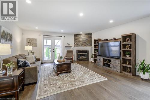 Spacious living area featuring wide plank wood-finish flooring, recessed lighting, and white walls - 29 Wiltshire Place, Ancaster, ON - Indoor Photo Showing Living Room With Fireplace
