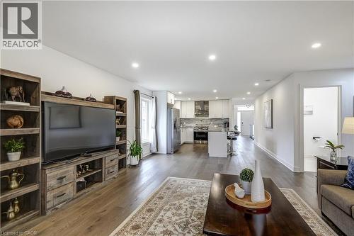 Open-concept living area featuring wood-finish flooring, recessed lighting, and a white color palette - 29 Wiltshire Place, Ancaster, ON - Indoor Photo Showing Living Room