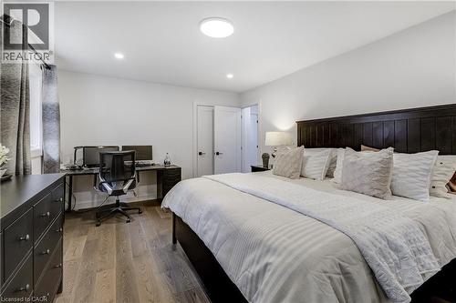 Spacious interior featuring wood-finish flooring, recessed lighting, and a dark wood paneled headboard - 29 Wiltshire Place, Ancaster, ON - Indoor Photo Showing Bedroom