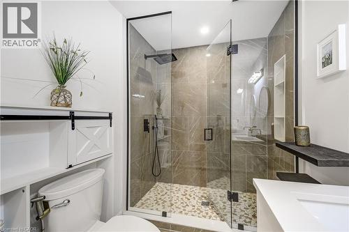 Glass-enclosed shower with large format tile surround and pebble tile flooring - 29 Wiltshire Place, Ancaster, ON - Indoor Photo Showing Bathroom