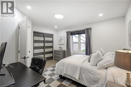 Bedroom featuring light wood-finish flooring, recessed lighting, and a window with dark drapery - 29 Wiltshire Place, Ancaster, ON - Indoor Photo Showing Bedroom