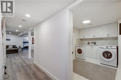 Dedicated laundry area featuring white cabinetry, a countertop, and a tiled backsplash - 29 Wiltshire Place, Ancaster, ON - Indoor Photo Showing Laundry Room
