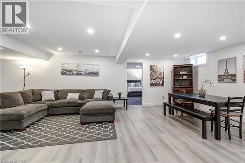 Spacious lower-level living area featuring light wood-finish flooring, recessed lighting, and white walls - 29 Wiltshire Place, Ancaster, ON - Indoor Photo Showing Living Room