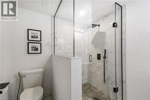 Glass-enclosed shower featuring a rain shower head, hand-held spray, and black matte fixtures - 29 Wiltshire Place, Ancaster, ON - Indoor Photo Showing Bathroom