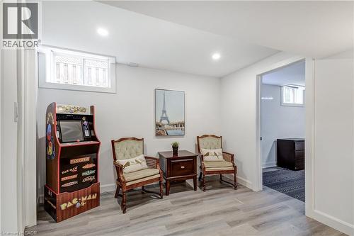 Finished basement area featuring recessed lighting, a window with exterior grating, and light wood-finish flooring - 29 Wiltshire Place, Ancaster, ON - Indoor