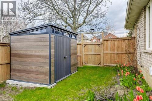 Modern storage shed with wood-finish siding, dark trim, and transom windows - 29 Wiltshire Place, Ancaster, ON - Outdoor