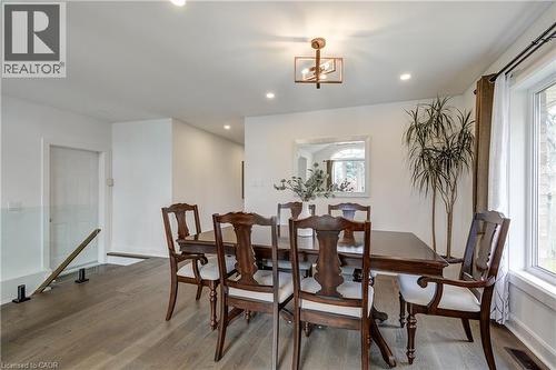 Dining area featuring wood-finish flooring, white walls, and a large window with white trim - 29 Wiltshire Place, Ancaster, ON - Indoor Photo Showing Dining Room