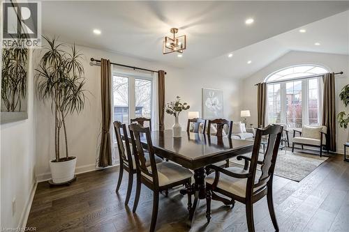 Spacious dining area featuring wood-finish flooring, a vaulted ceiling with recessed lighting, and a decorative chandelier - 29 Wiltshire Place, Ancaster, ON - Indoor Photo Showing Dining Room