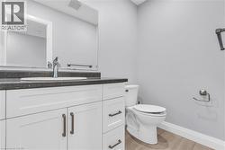 Bathroom featuring a white vanity with dark countertop, undermount sink, and chrome faucet - 
