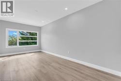 Bright interior space featuring a large horizontal window and light wood-finish flooring - 