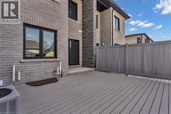 Spacious outdoor deck featuring composite decking and a privacy fence - 