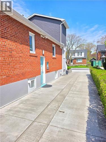 Red brick exterior with white trim windows and entrance to the basement floor units - 16 Forest Hill Road, St. Catharines, ON - Outdoor With Exterior