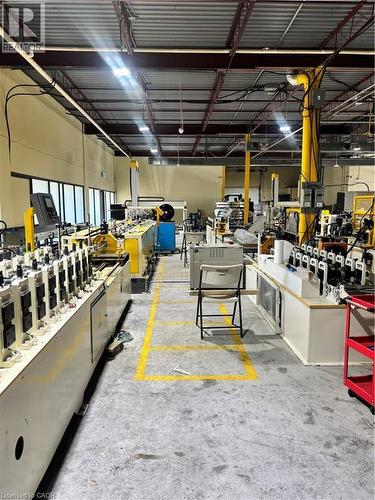 Industrial warehouse space featuring concrete flooring, high ceilings with exposed metal beams, and fluorescent lighting - 550 Parkside Drive Unit# A13-16, Waterloo, ON 