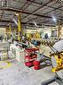 Industrial space featuring high ceilings with exposed structural beams, fluorescent lighting, concrete flooring with yellow safety markings, and large-scale manufacturing equipment - 550 Parkside Drive Unit# A13-16, Waterloo, ON 