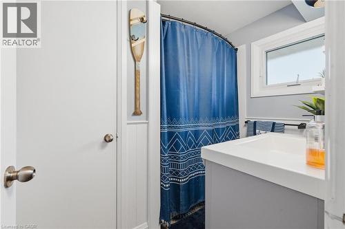 Bathroom vanity featuring an integrated white sink, single-handle faucet, and gray cabinetry - 120 Elgin Crescent, Waterloo, ON - Indoor Photo Showing Other Room