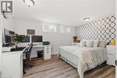 Bedroom featuring wood-finish flooring, recessed windows with white blinds, and a decorative accent wall - 120 Elgin Crescent, Waterloo, ON - Indoor Photo Showing Bedroom