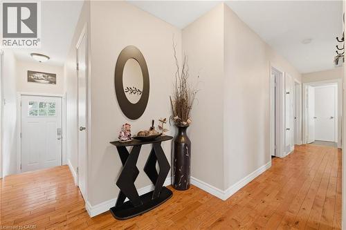 Hallway with wood-finish flooring, light neutral wall color, white baseboards, and multiple doorways - 120 Elgin Crescent, Waterloo, ON - Indoor Photo Showing Other Room