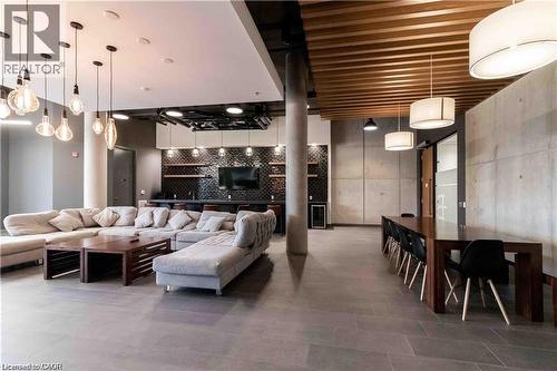 Spacious common area featuring large format tile flooring, a slatted wood ceiling detail, and concrete panel walls - 251 Northfield Drive E Unit# 406, Waterloo, ON - Indoor