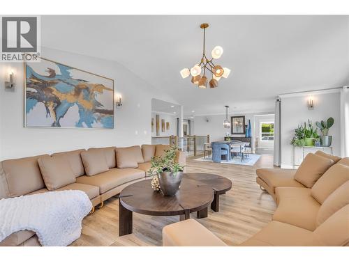 Party size living and dining room with vaulted ceiling and triple slide doors to the lake view deck - 4325 Takla Road, Kelowna, BC 