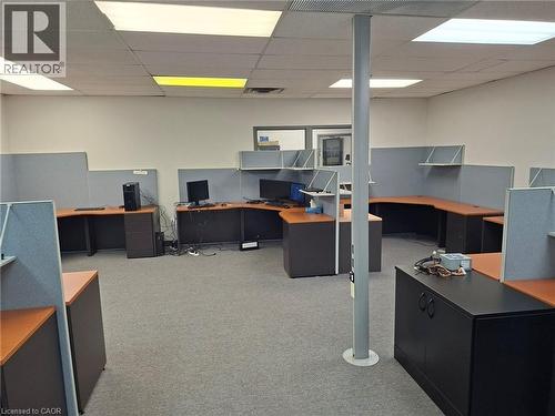 Open commercial space with textured carpet flooring, acoustical ceiling tiles, and white walls - 920 Sheldon Court, Burlington, ON 
