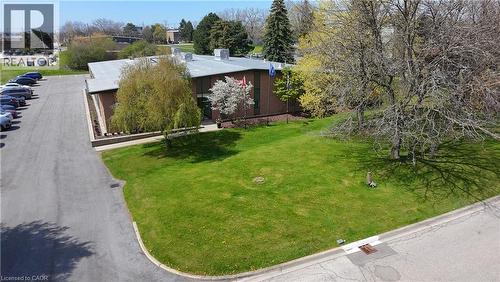 Commercial building featuring a brick facade, flat roof, and an adjacent asphalt parking lot - 920 Sheldon Court, Burlington, ON 