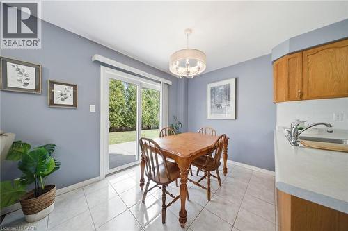 Dining area with direct patio access, featuring light-toned tile flooring and a suspended drum chandelier - 200 Morrison Drive, Caledonia, ON - Indoor Photo Showing Dining Room