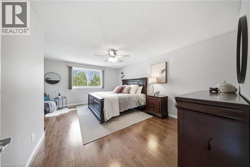 Spacious room featuring wood-finish flooring, a contemporary ceiling fan, and ample natural light from a wide window - 200 Morrison Drive, Caledonia, ON - Indoor Photo Showing Bedroom