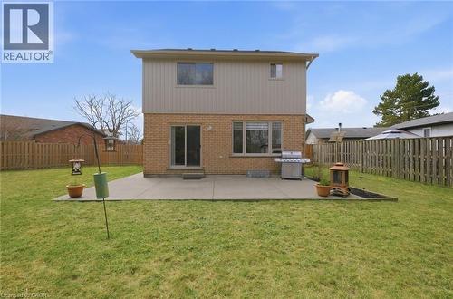 Expansive backyard featuring a large concrete patio, brick and siding exterior, and a privacy fence - 200 Morrison Drive, Caledonia, ON - Outdoor