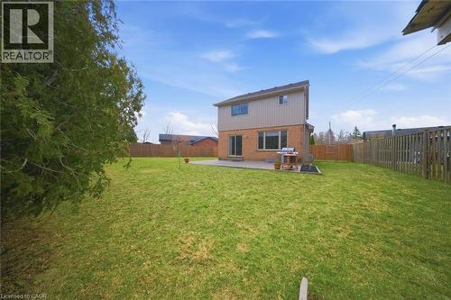Expansive backyard featuring a large green lawn, concrete patio, and mature perimeter fencing - 200 Morrison Drive, Caledonia, ON - Outdoor