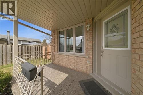 Sheltered front porch featuring brick siding, a decorative glass entry door, multiple windows, and a metal railing - 200 Morrison Drive, Caledonia, ON - Outdoor With Exterior