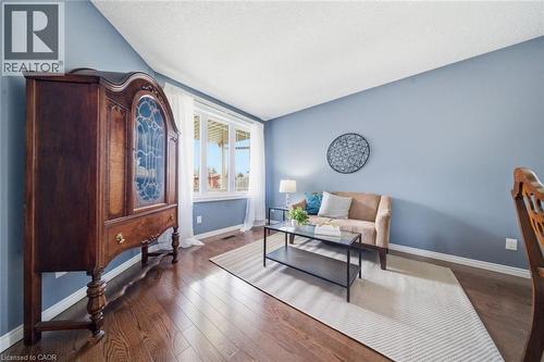 Spacious room featuring wood-finish flooring, light blue painted walls, white baseboards, and a white popcorn ceiling - 200 Morrison Drive, Caledonia, ON - Indoor Photo Showing Living Room