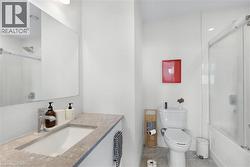 Bathroom featuring a single vanity with an undermount sink, a gray stone countertop, and a chrome faucet - 