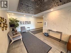 Entryway featuring a decorative ceiling panel, recessed lighting, large format tile flooring, and a marble-finish accent wall - 