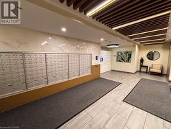 Modern mailroom with extensive individual mailboxes, light-toned tile flooring, and integrated lighting - 