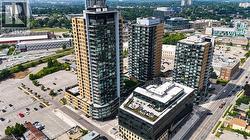 Modern high-rise residential building featuring a glass and panel exterior, multiple private balconies, and a distinctive curved corner - 