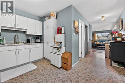 Kitchen featuring white cabinetry, a stainless steel sink with a high-arc faucet, and light-toned countertops - 