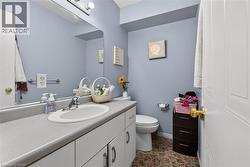 Bathroom featuring a white vanity with a gray countertop and an integrated sink - 