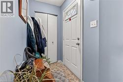 Entryway featuring a white paneled door with an arched decorative glass insert and a bifold closet door - 