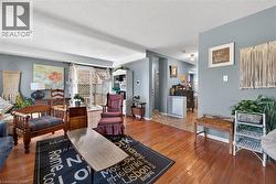 Living room featuring wood-finish flooring, light gray walls, and a sliding glass door - 