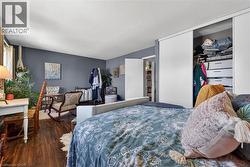 Bedroom with wood-finish flooring, sliding closet doors, and painted walls - 