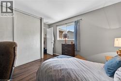 Bedroom featuring wood-finish flooring, a double sliding closet, and an operable window - 
