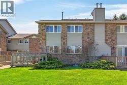 Rear exterior featuring a brick facade, light-colored siding, and multiple windows - 
