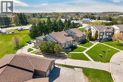Multi-unit residential complex featuring brown shingle roofing and light-colored stone and siding exteriors - 